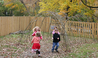 Kids playing under a stick tunnel