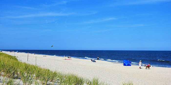 Long white beach with a blue sky and ocean in the backdrop