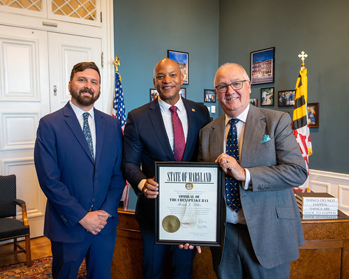 Maryland DNR Secretary Josh Kurtz and Governor Wes Moore present Professor Thomas Miller with the ‘Admiral of the Chesapeake Bay’ Award. They're in the Governor's Office.