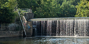 The new eel ladder (at left) is a modest PVC pipe that spans about 43 feet up the edge of Daniels Dam. It has a few openings on the top along its length for upkeep. Photo by Joe Zimmermann