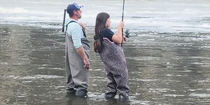Frankie Goff fights a striped bass under the watchful eye of her dad. Photo courtesy of Don Goff