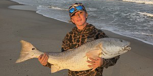 Lilly Eberhard holds up a nice red drum for a picture before sliding it back into the surf. 
