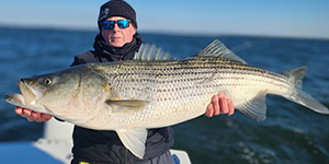 Steve Morgan holds up a beautiful striped bass for a quick picture before releasing it. Photo by Jamie Clough