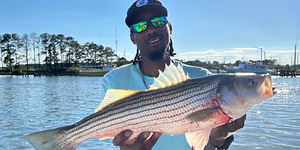 This happy angler holds up a keeper-sized striped bass caught in the Kent Narrows area.
