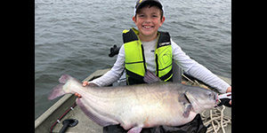 Young Logan Ortel is all smiles with this large blue catfish he caught. Photo by Tim Ortel.