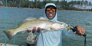 Rustin Moore holds a beautiful speckled trout he caught recently in the lower Bay.