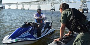 A fisherman on a personal watercraft shows his Maryland license to a Natural Resources Police officer on patrol. Maryland DNR photo.