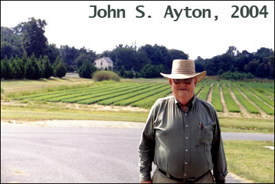 John S. Ayton stadnding inf front of a large garden