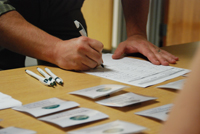 A person signing up and getting a name tag.