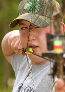 Young man shooting a bow.