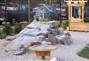 Sand play area with climbing boulders at Johns Hopkins Homewood Early Learning Center