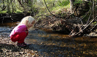 Girl by a small stream