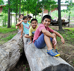 Children climbing on a log at Robinson Nature Center
