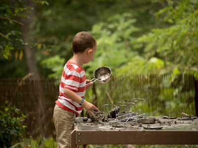 Kid playing with mud and dirt on a table