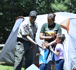 Veteran and daughter setting up camp with a Park Ranger