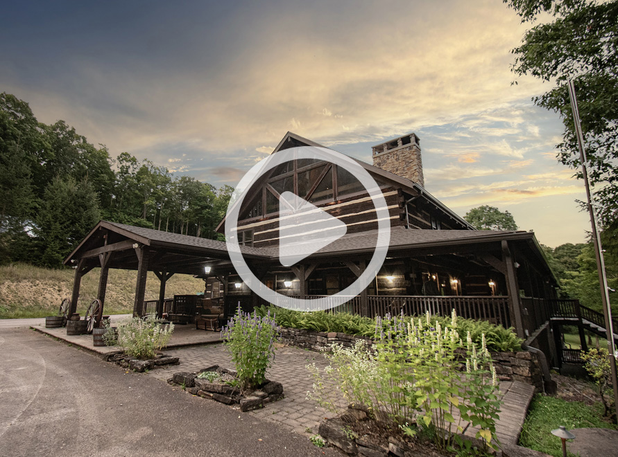 Lodge with blue sky, an alpine style lodge with wrap around porch and a-frame ceiling.