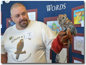 A volunteer holds an owl at the State Fair