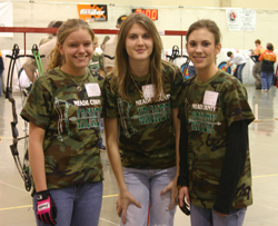 3 young female students at archery tournament 