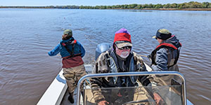 Maryland Department of Natural Resources biologists Marisa Ponte, Jim Uphoff, and Shannon Moorhead traverse the quiet Choptank River, casting out a net to collect samples of striped bass eggs and larvae. Photo by Joe Zimmermann, Maryland DNR.