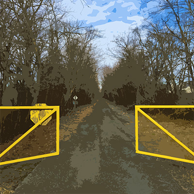 Western Maryland Rail Trail Yellow gate, slightly ajar, leading to the entrance of the paved trail.